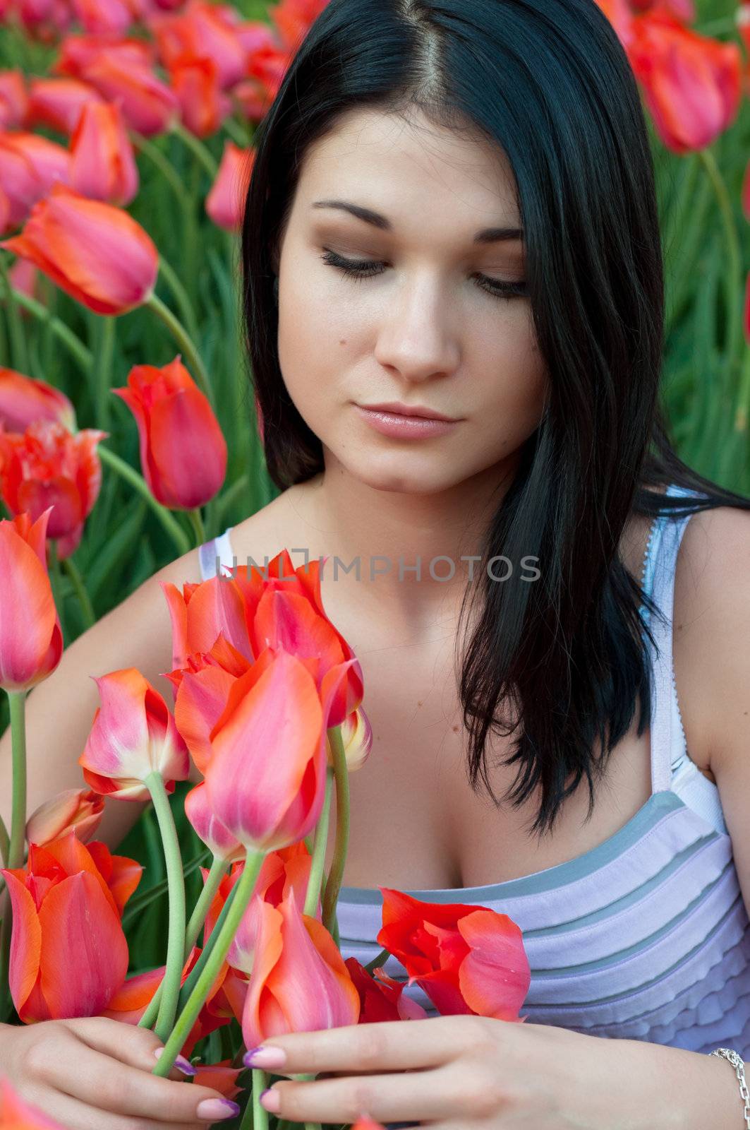 Sad girl looks at the beautiful flowers that are everywhere.