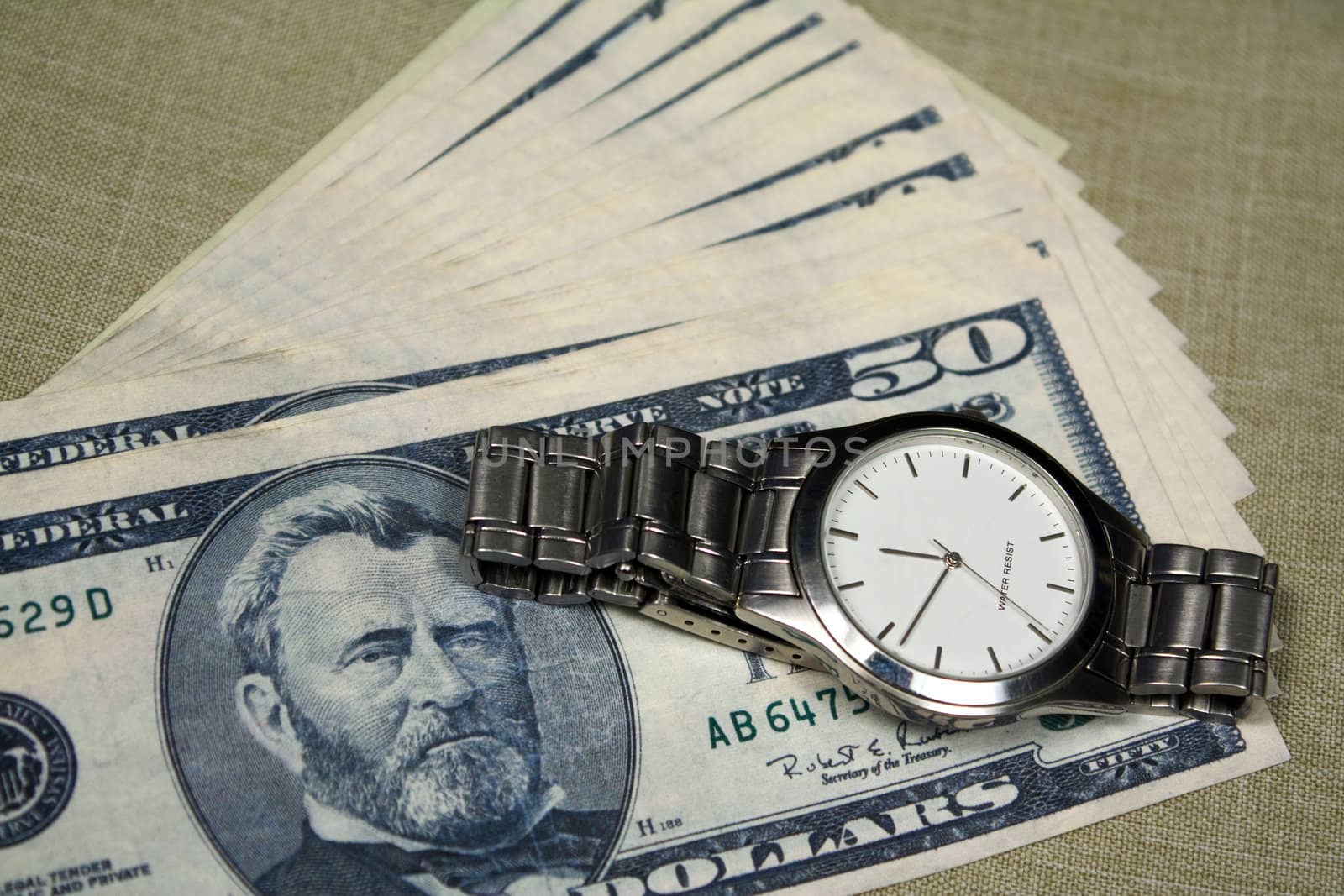 Some fifty dollars notes and watch with white clock face