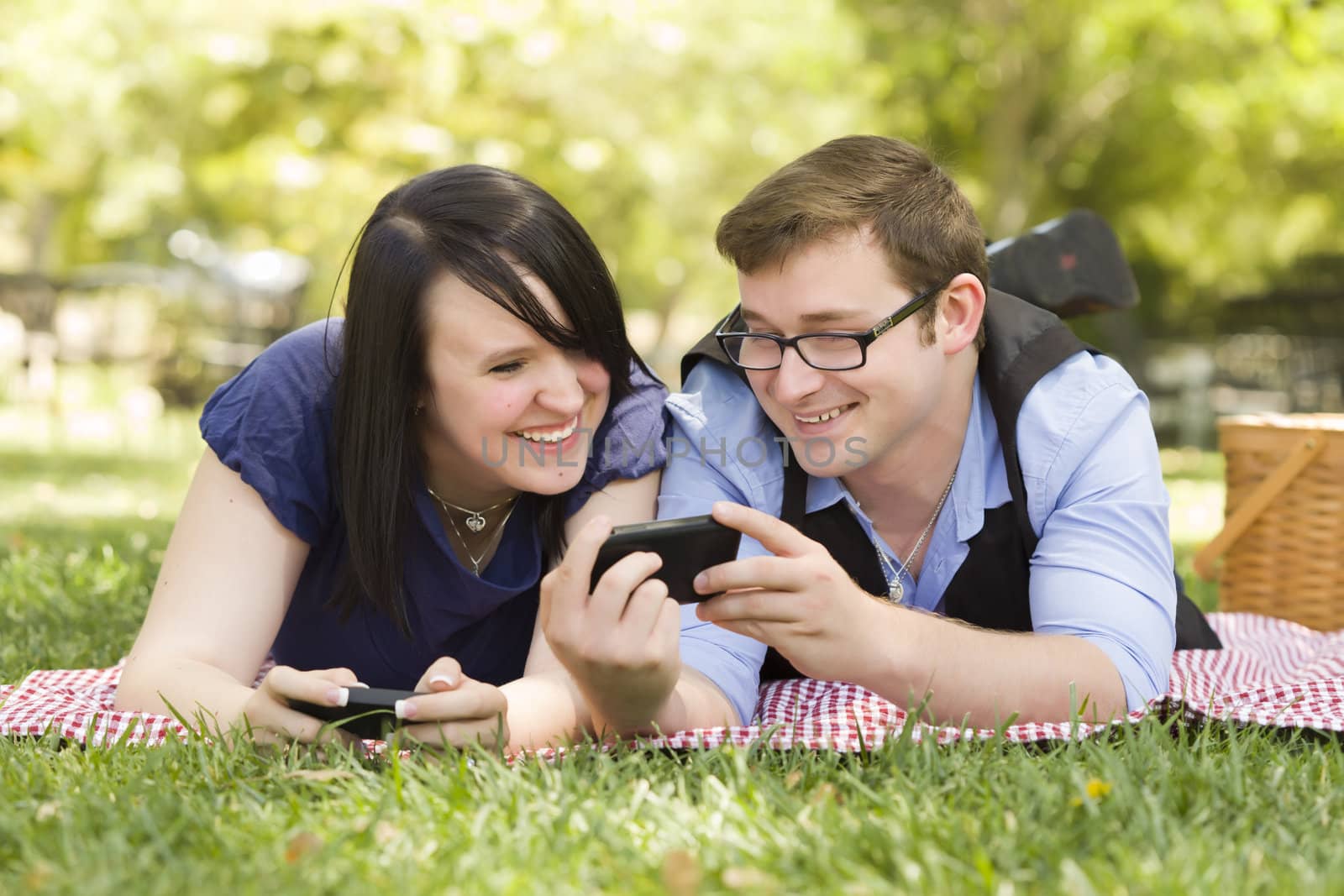 Young Couple at Park Texting Together by Feverpitched