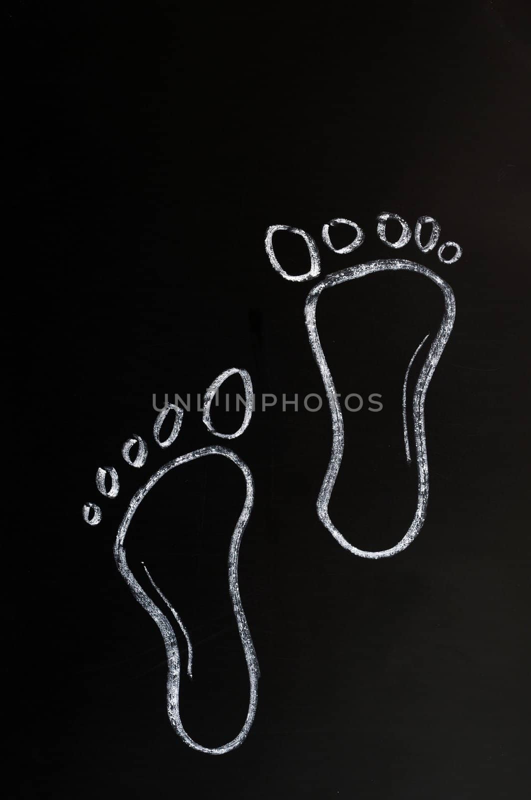 Footprints drawn with white chalk on a blackboard