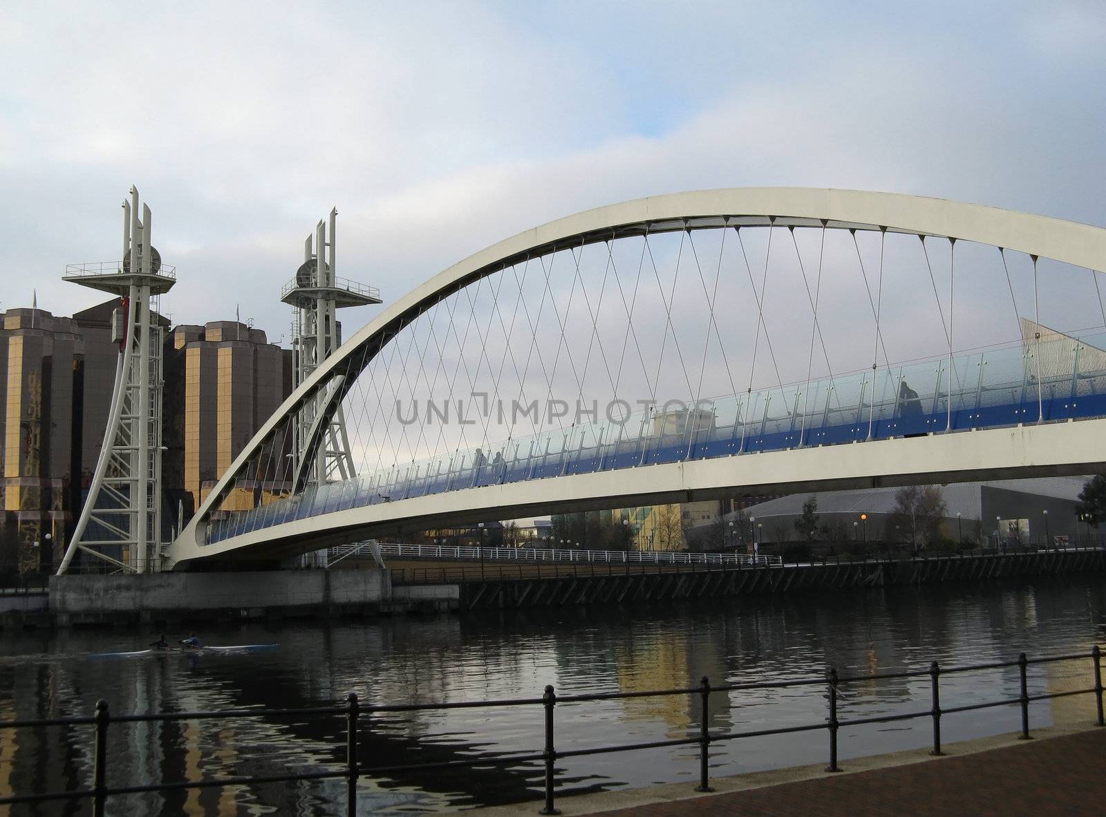  View of the Millennium Lifting Footbridge in Manchester with building reflections on the water.