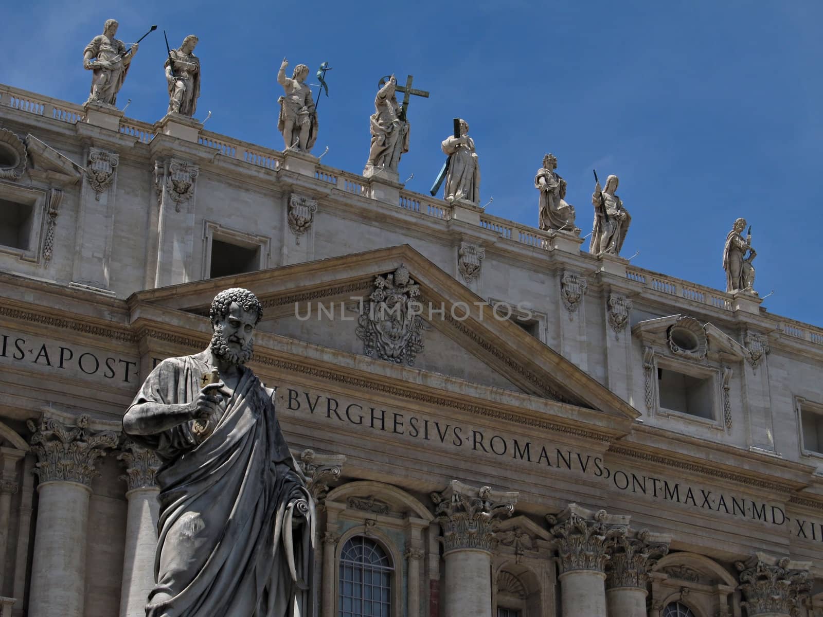 View of the facade of The Papal Basilica with the statue of Saint Peter in front.