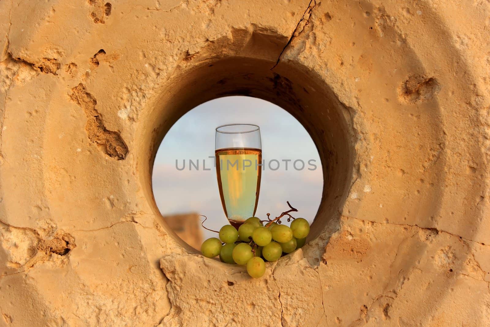 glass of white wine and a bunch of grapes by irisphoto4