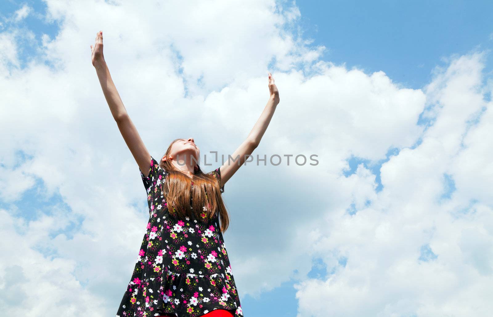 Teen girl with raised hands by AndreyKr