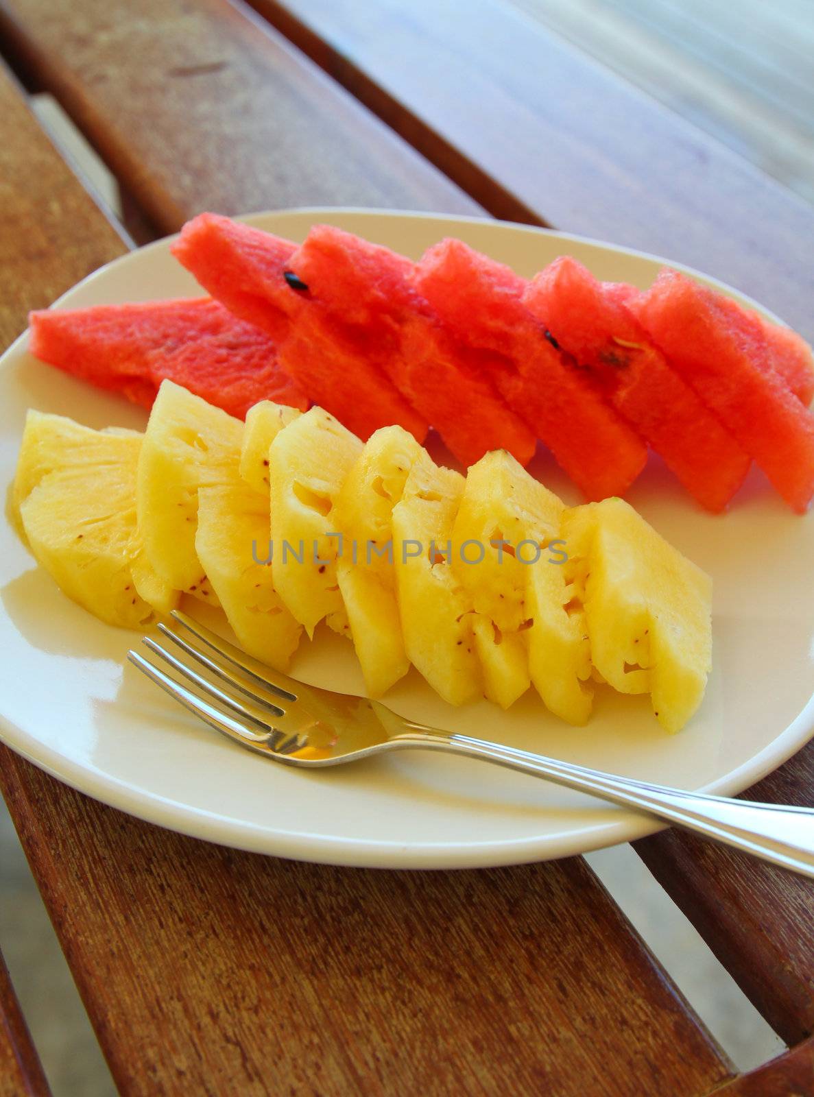 Watermelon and pineapple on dish with fork by nuchylee