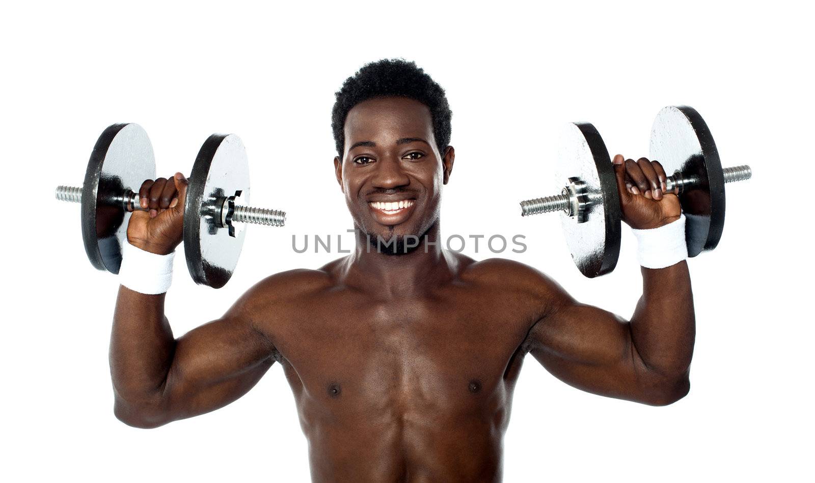 Male athlete holding dumbbells above his shoulders