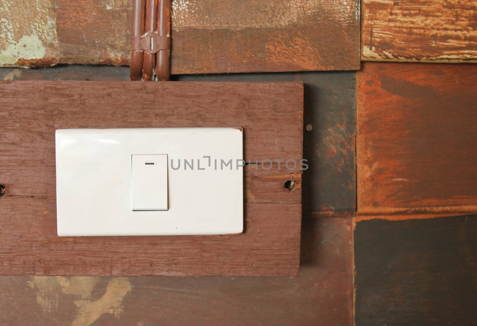 Switch button on grunge wooden wall by nuchylee