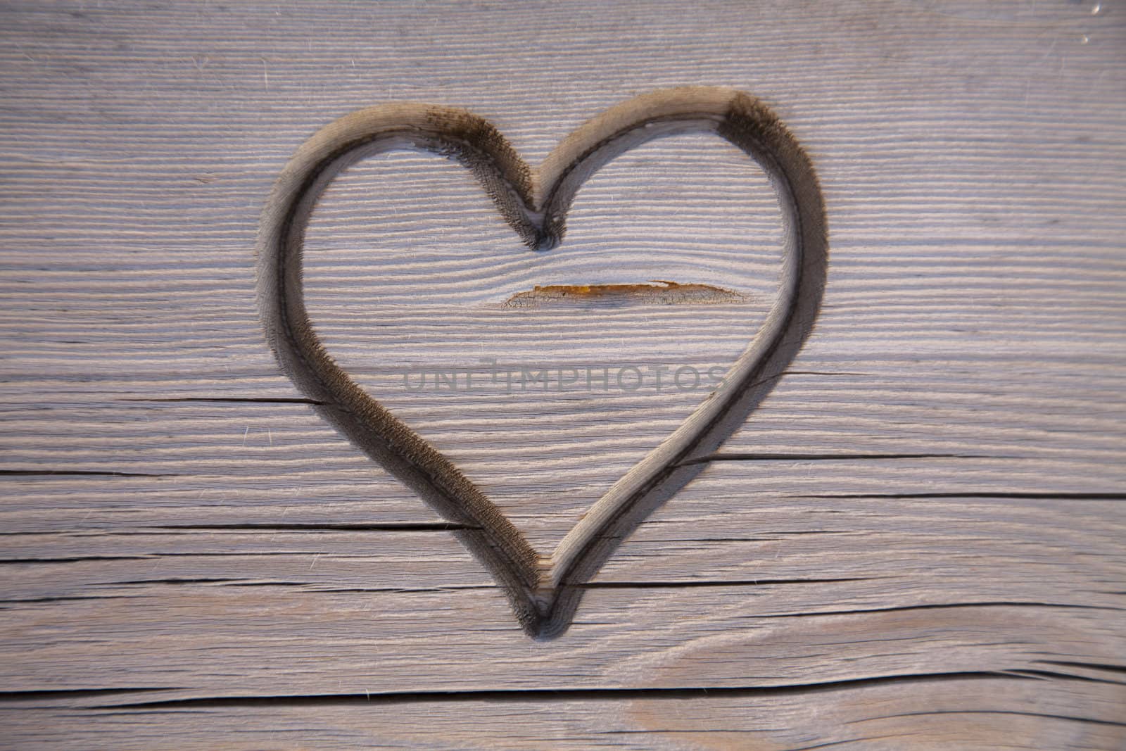 Perfect heart carved in a wooden park bench