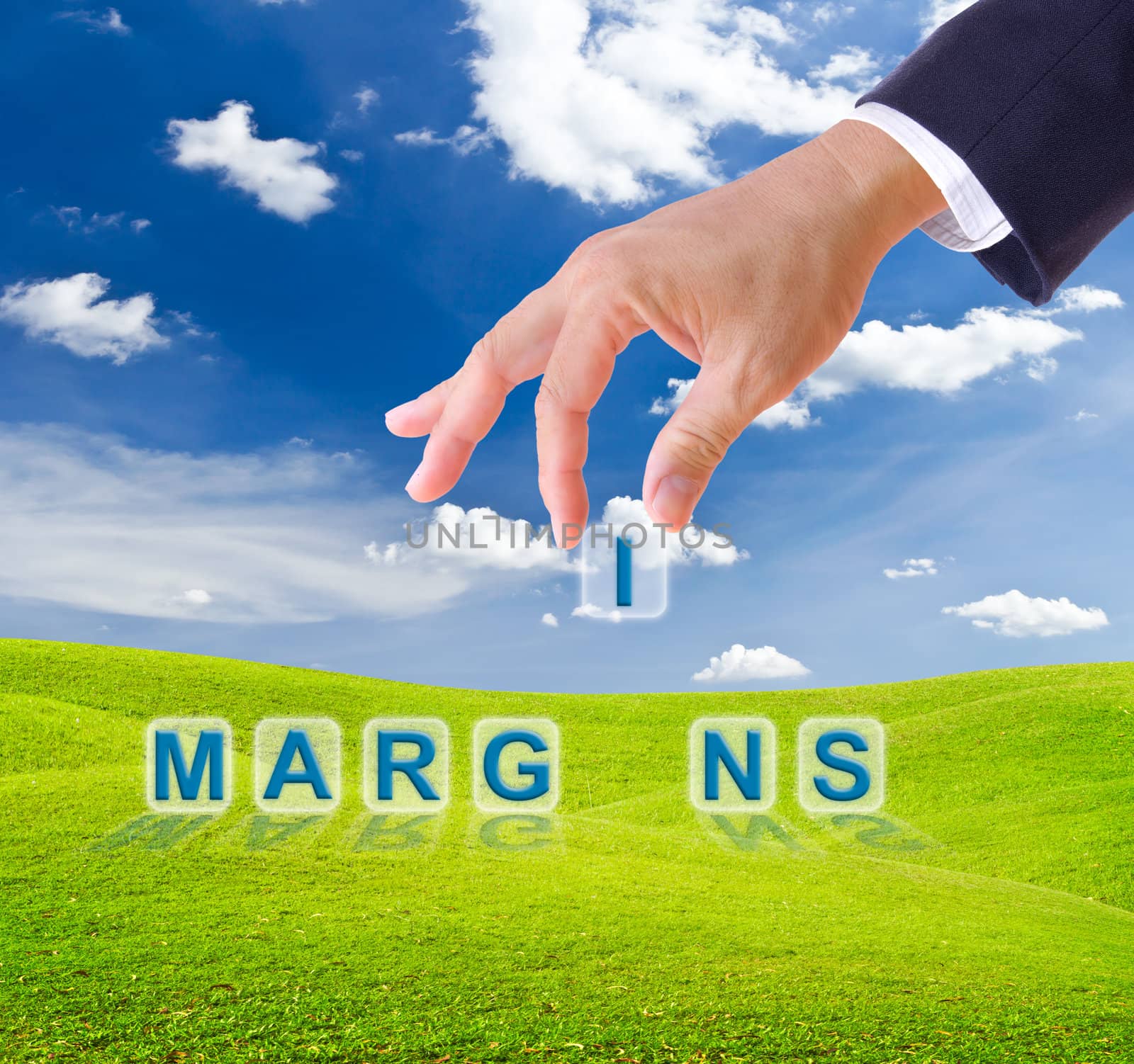 business man hand made margins word buttons on green grass meadow