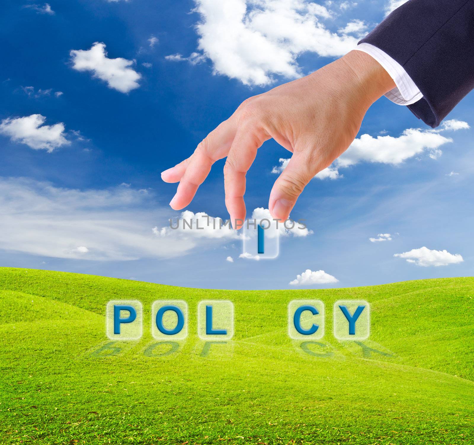 business man hand made policy word buttons on green grass meadow