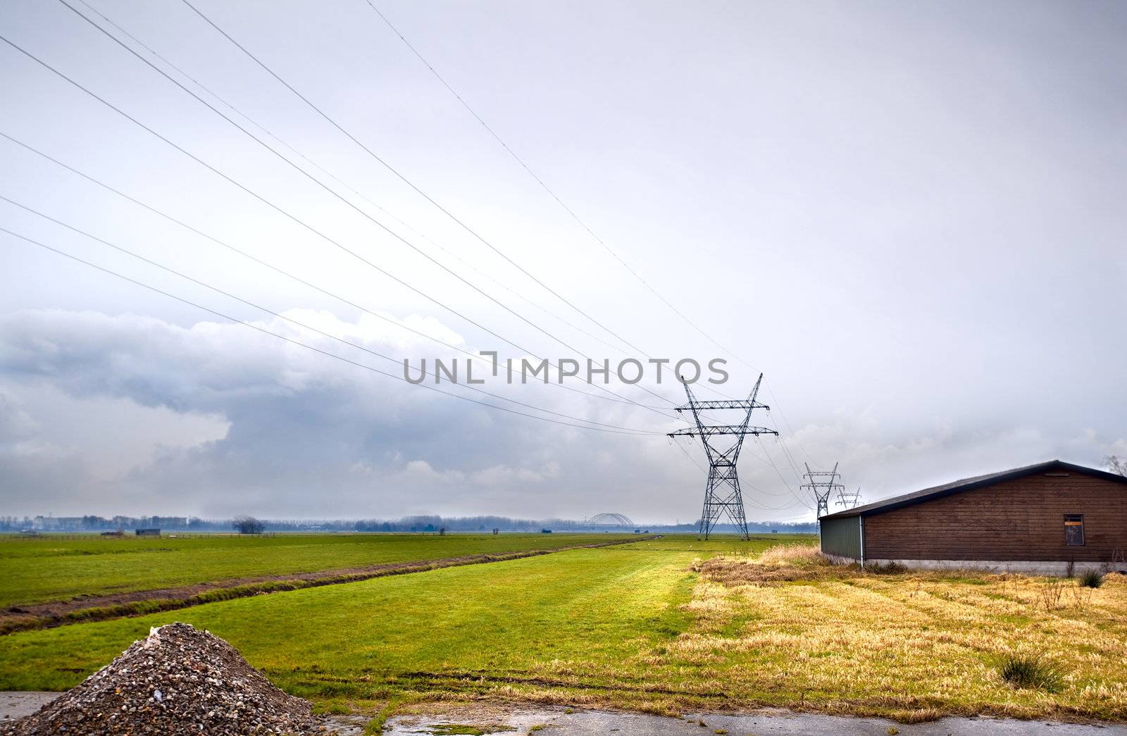 view on Dutch farm with fields and high voltage line