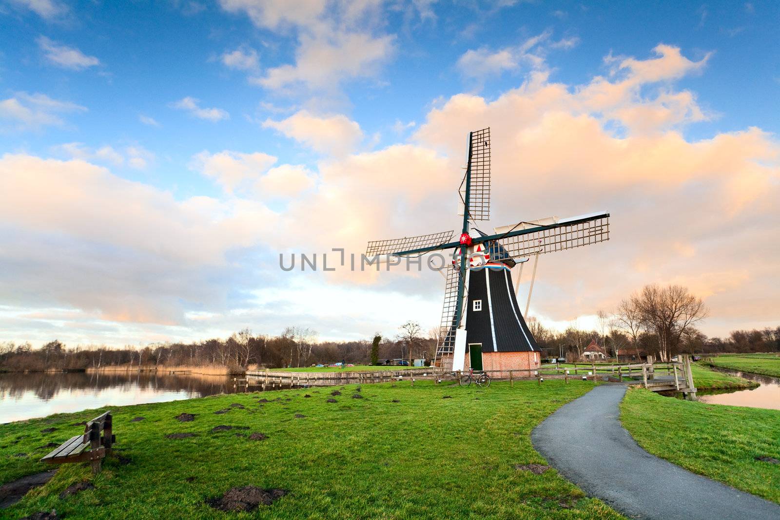 Dutch windmill over blue sky with white clouds before the sunset