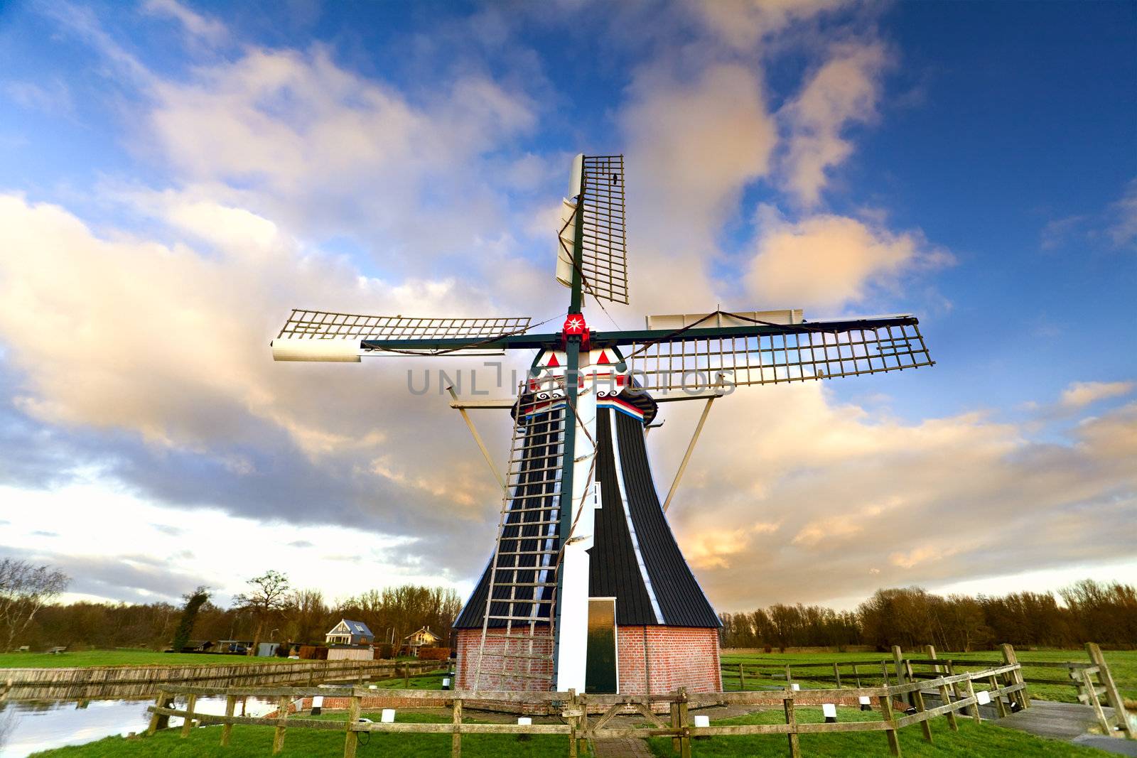 Dutch windmill over blue sky with white clouds 
