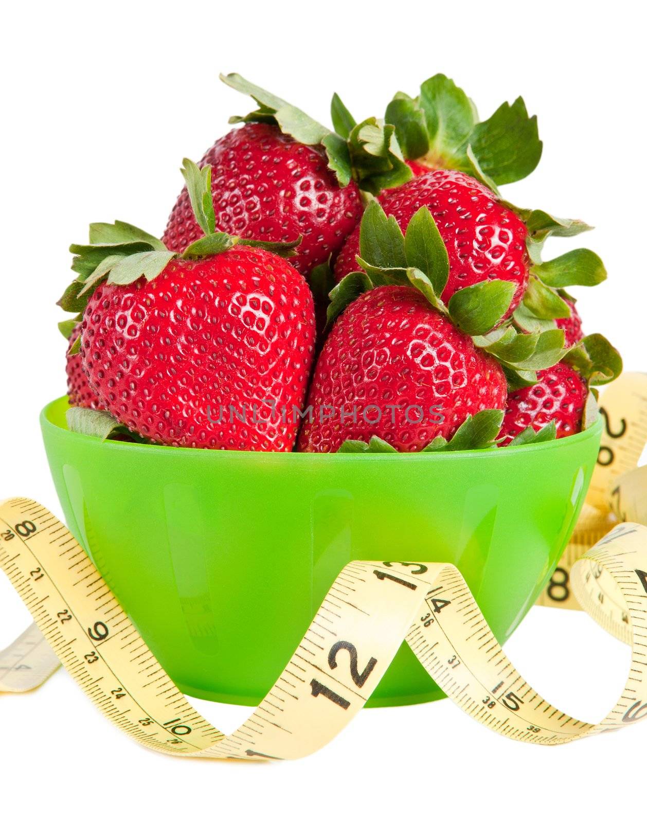 Green bowl of strawberries with a yellow measuring tape in front of it