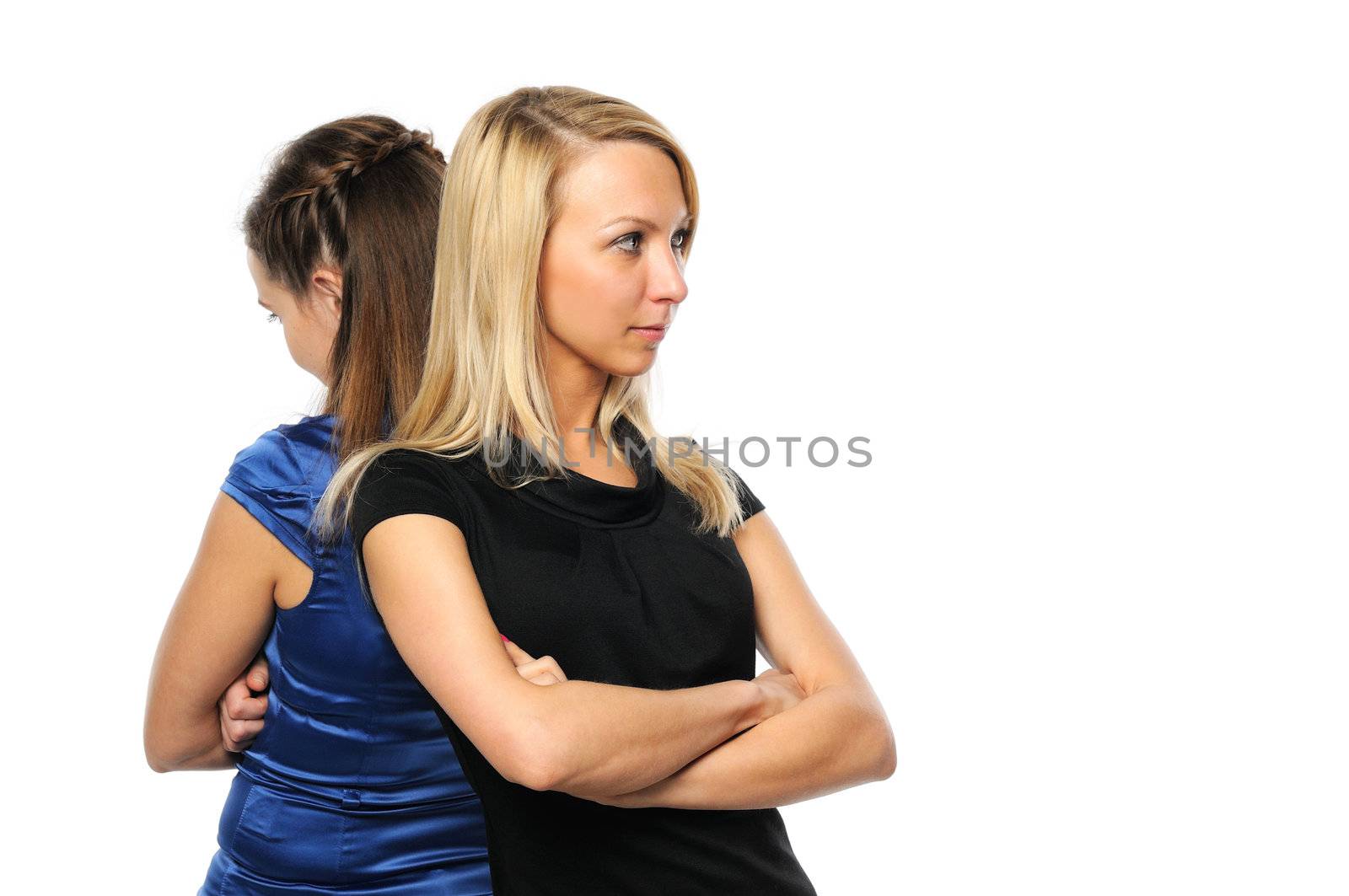 Two young attractive women standing back to back. Isolated on white.