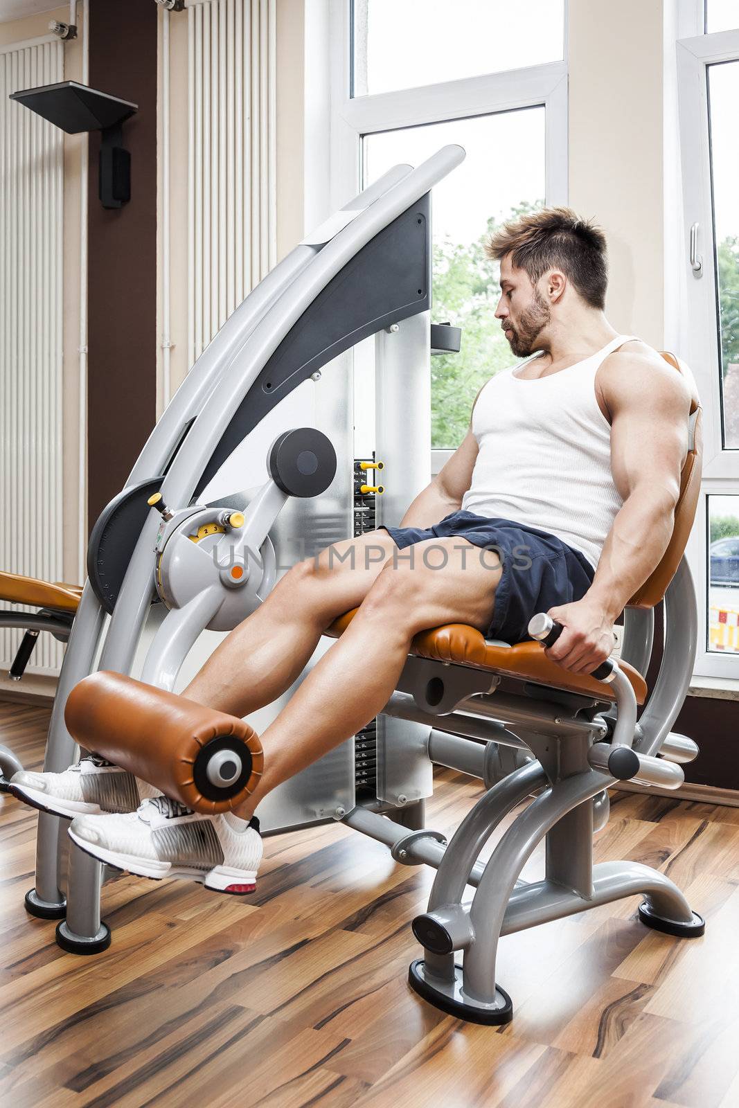 A handsome young muscular sports man doing leg press