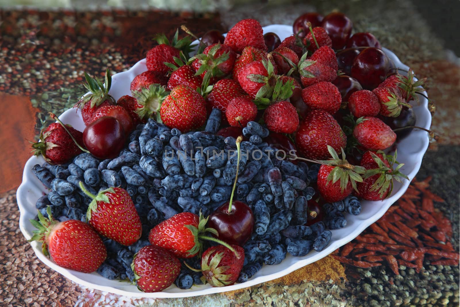 honeysuckle, strawberries and cherries on a plate