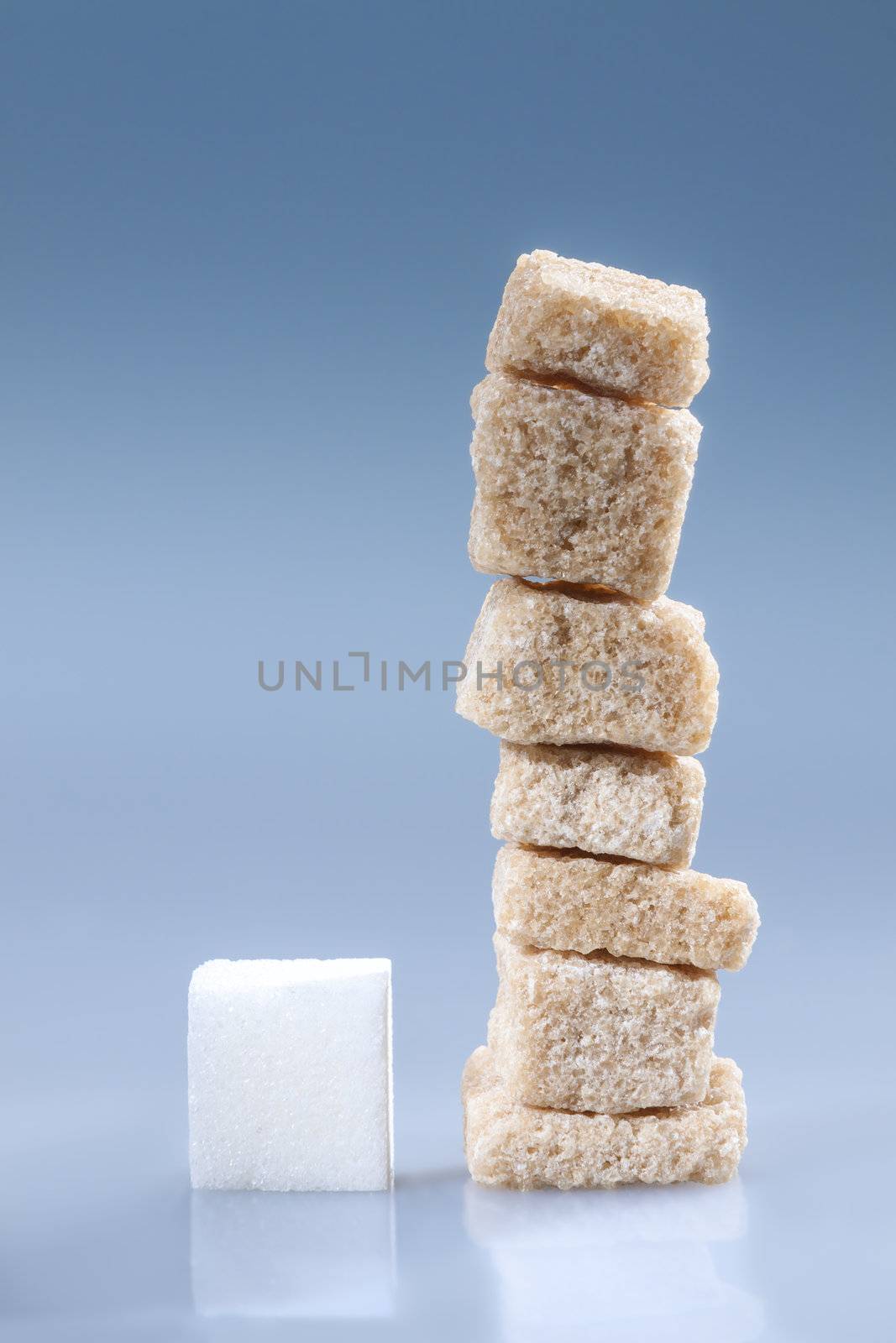 Vertical stack of brown and white sugar cubes on blue.