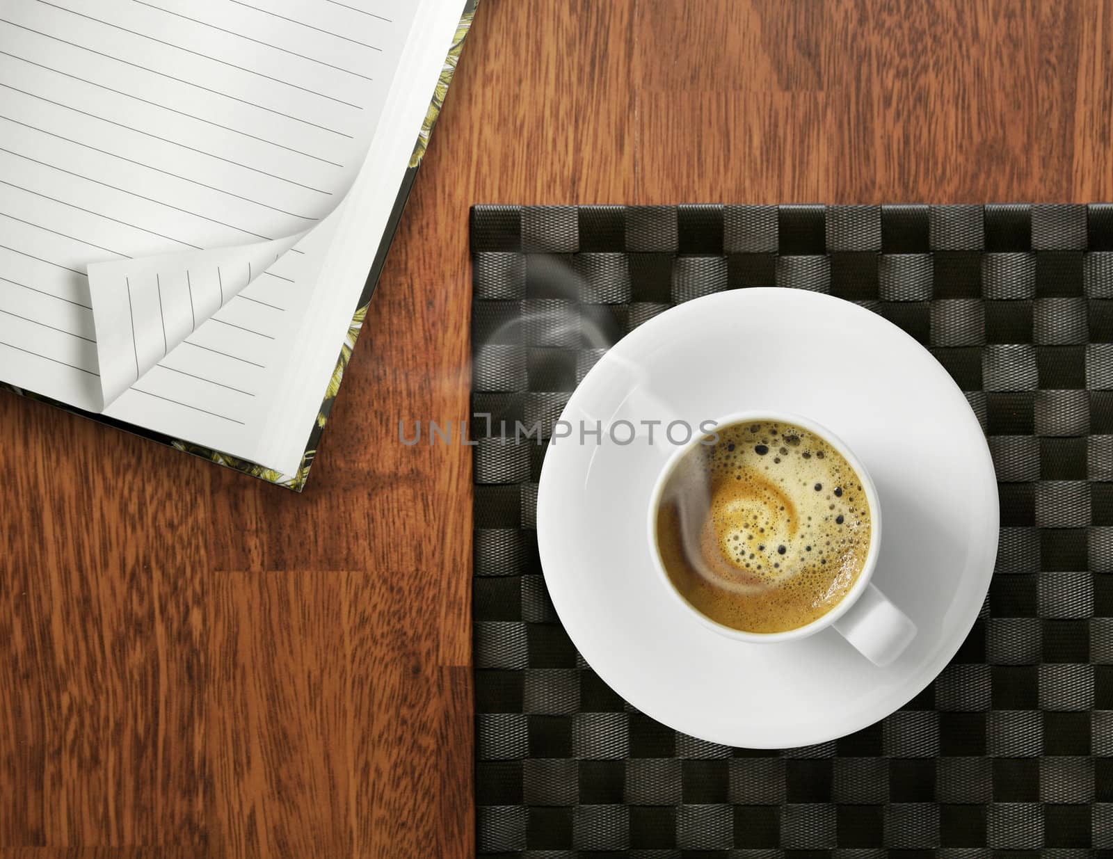 Cup of espresso coffee on wooden table , with open memo book