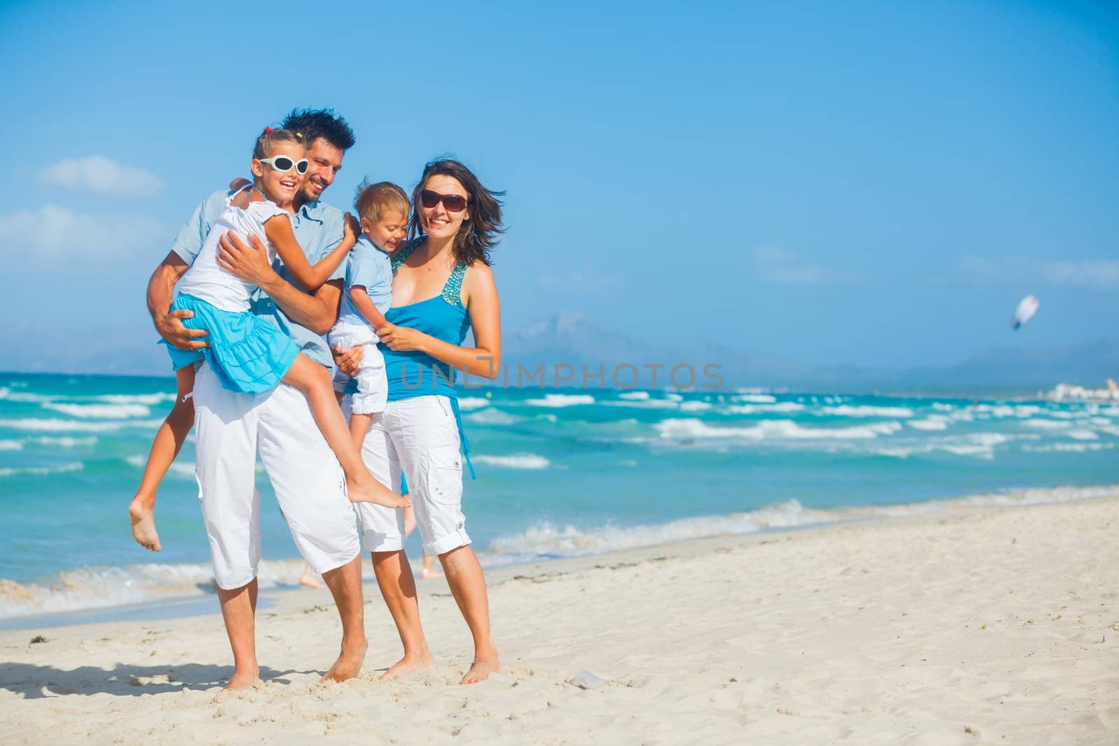 Family of four having fun on tropical beach