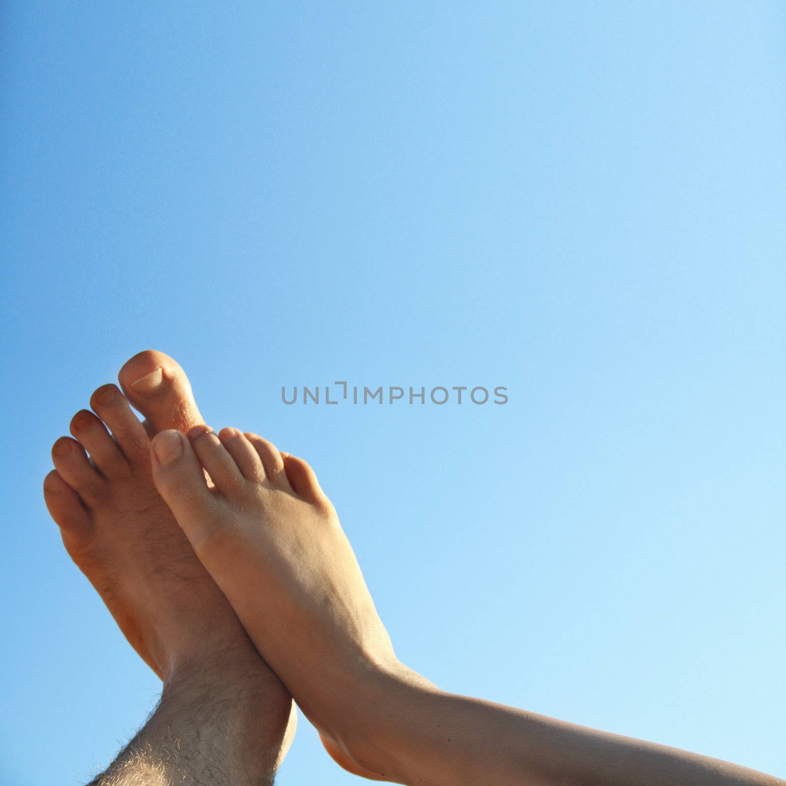 male and female legs on beautiful summer background by photochecker