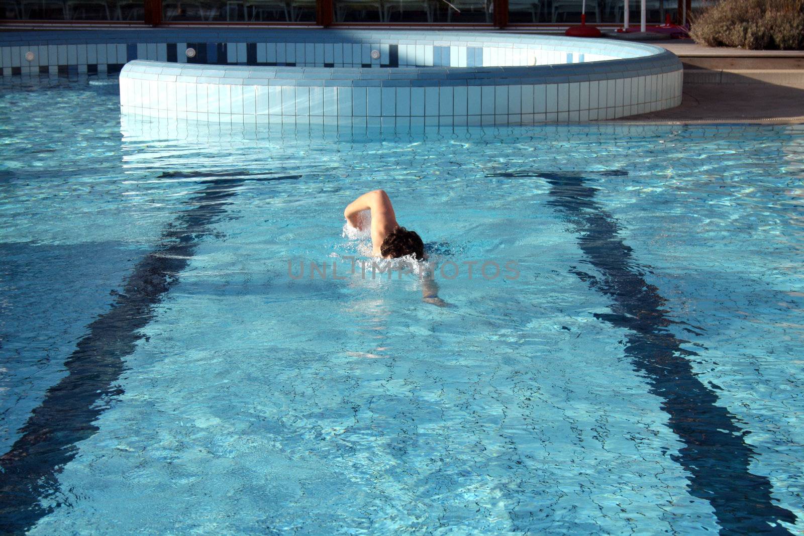 man swims in swimming pool