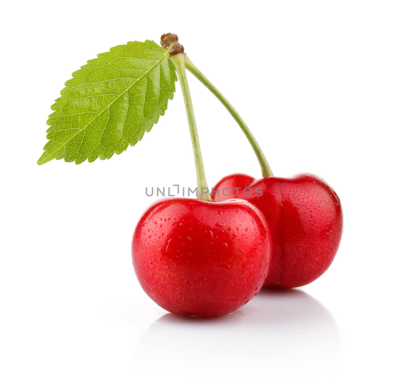 Ripe cherry berries with green leaf isolated on white by alphacell