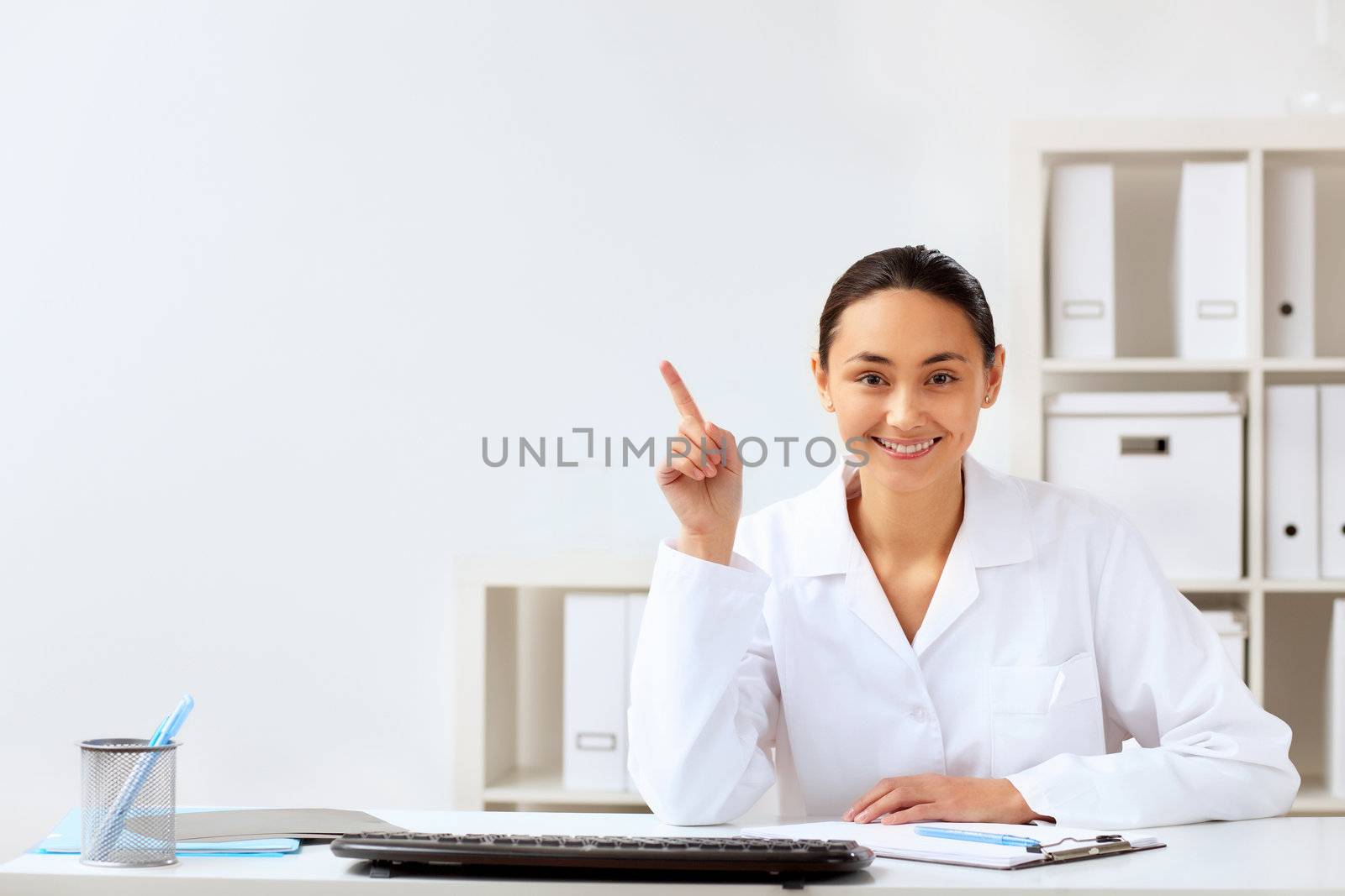 Young female doctor in white uniform at workplace