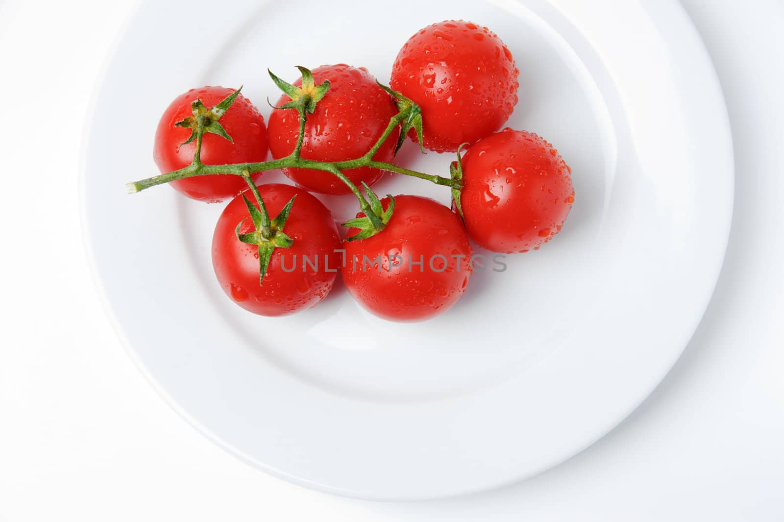 An image of fresh red tomatoes on a plate