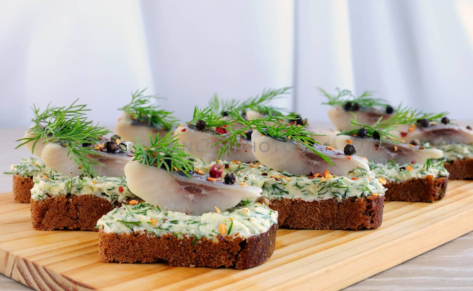 Snack rye bread with butter cream with herbs and spices herring