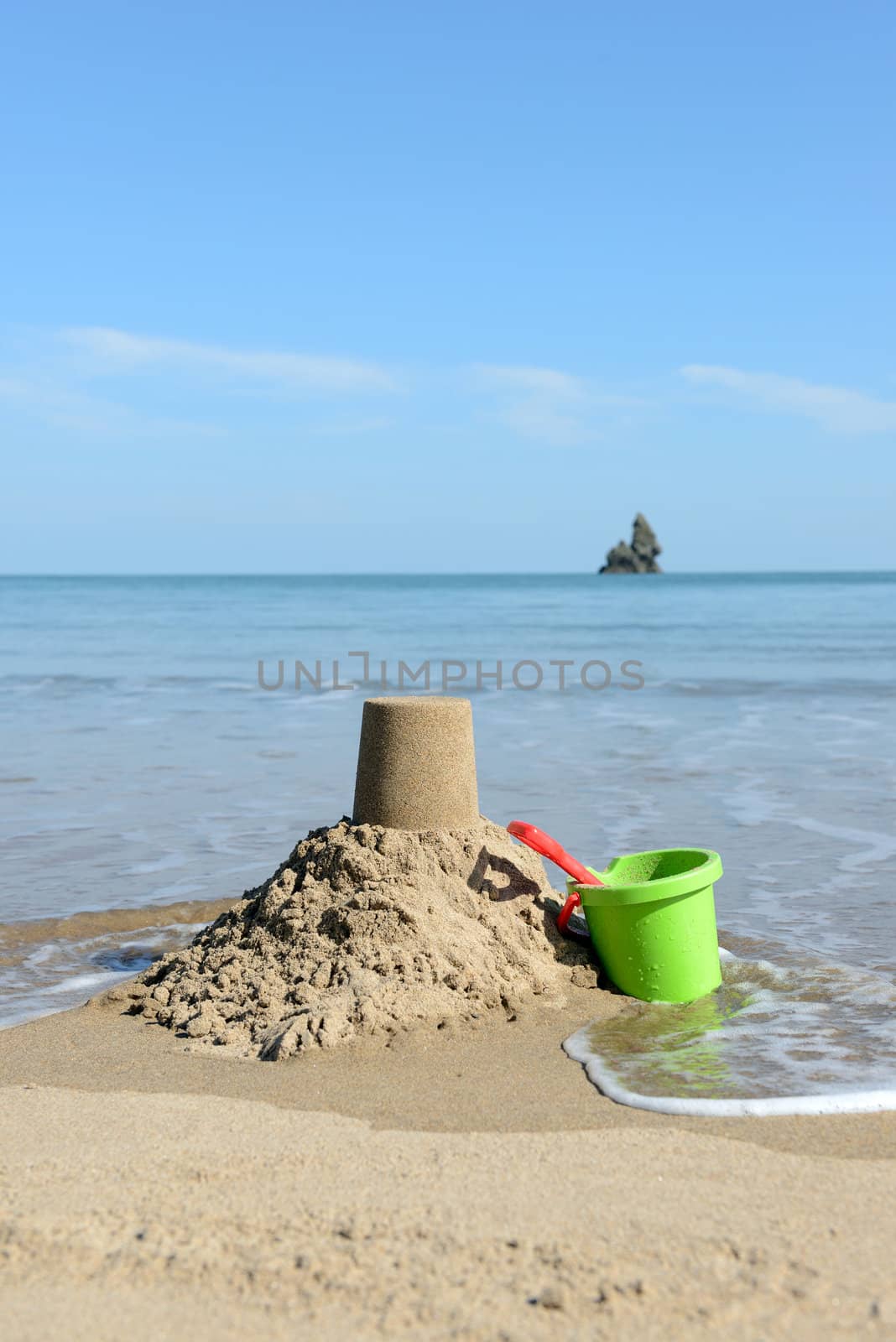beautiful  sunny day at the beach with Sandcastle, bucket and spade