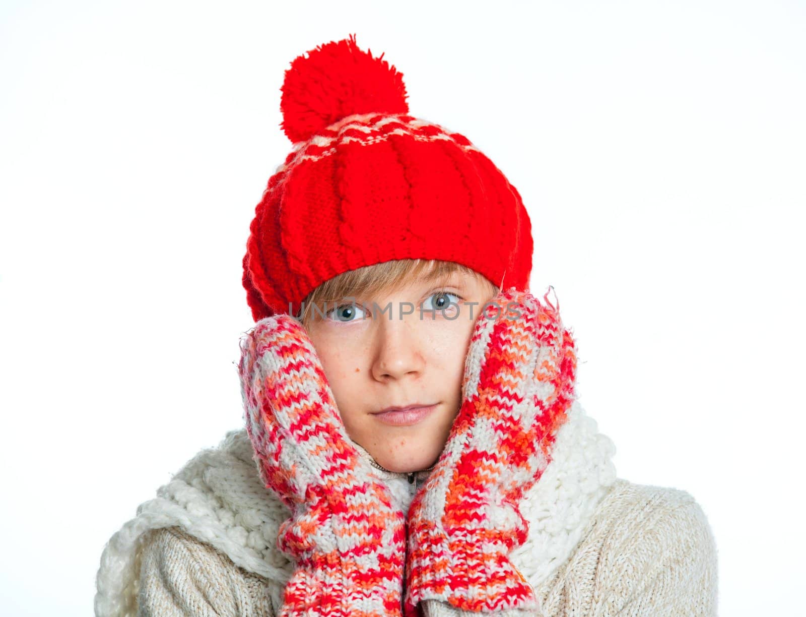 Portrait of young smiling cute teenager in a red hat and mittens, isolated on white