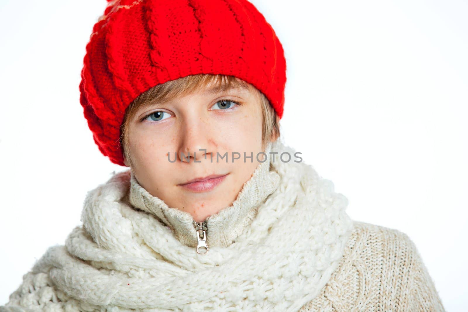 Portrait of young smiling cute teenager in a red hat and mittens, isolated on white