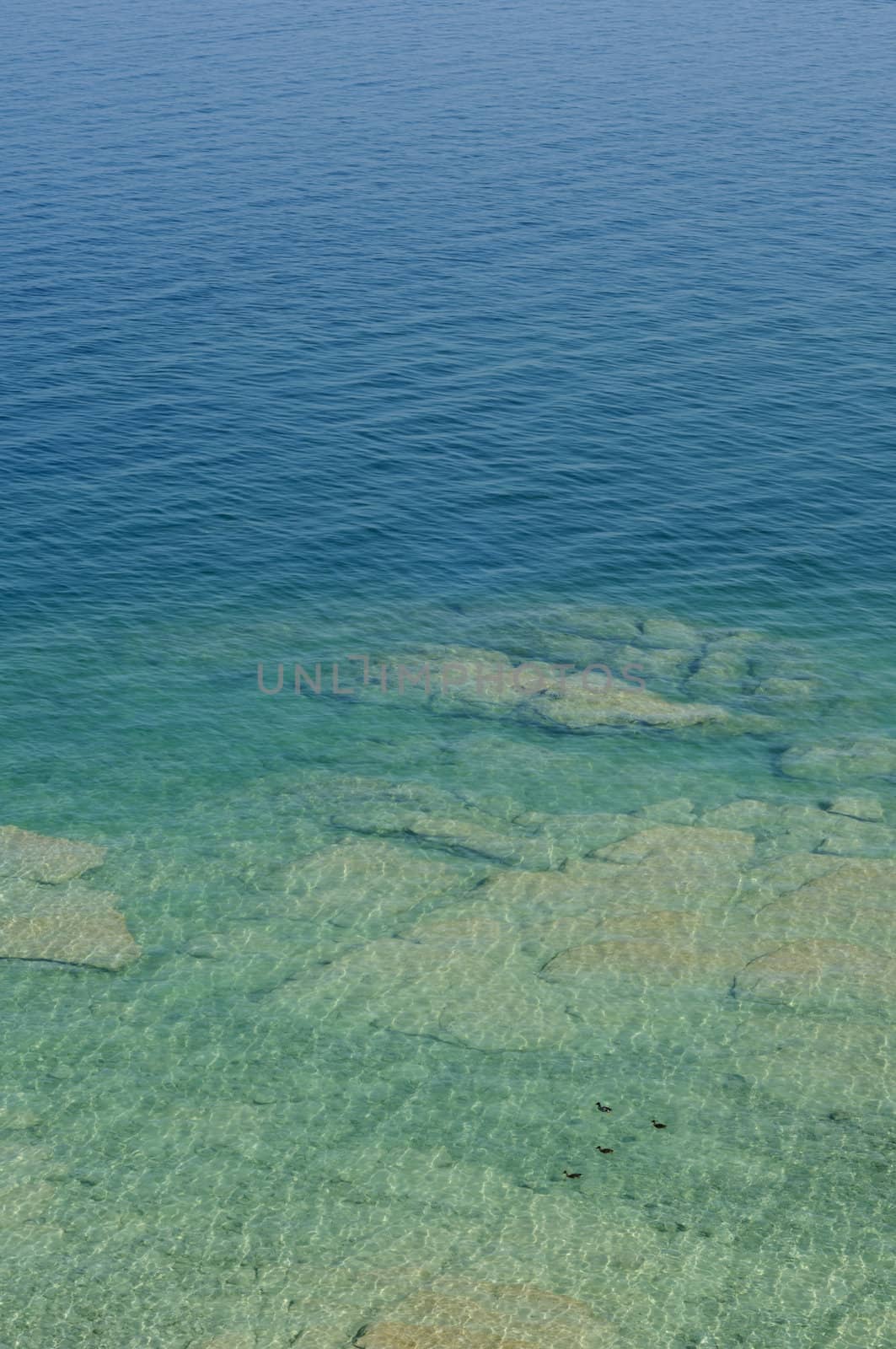 Rippled pattern background of clean and transparent water in Garda Lake, Northern Italy