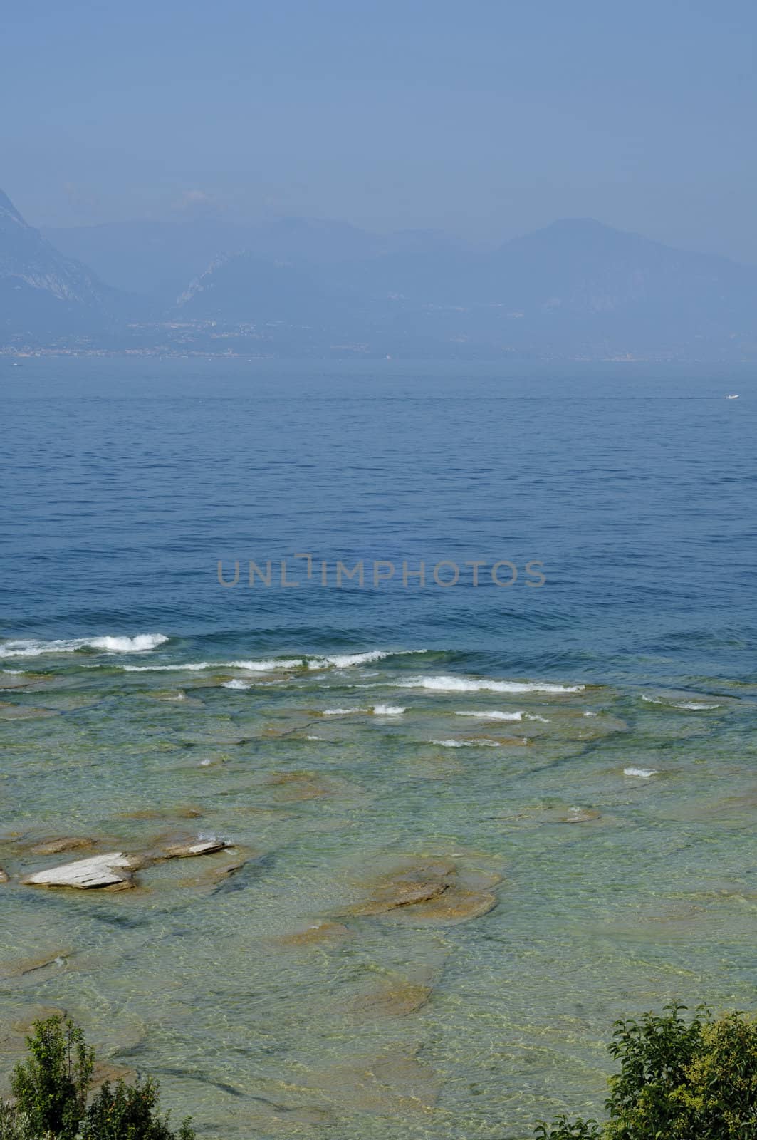 Rippled pattern background of clean and transparent water in Garda Lake, Northern Italy