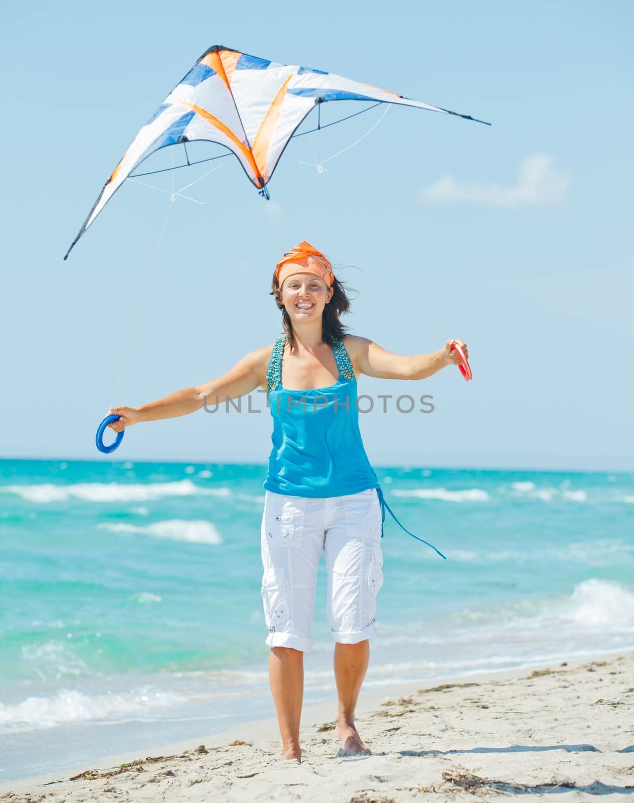 Young cute woman playing with a colorful kite on the tropical beach. Vertikal veiw