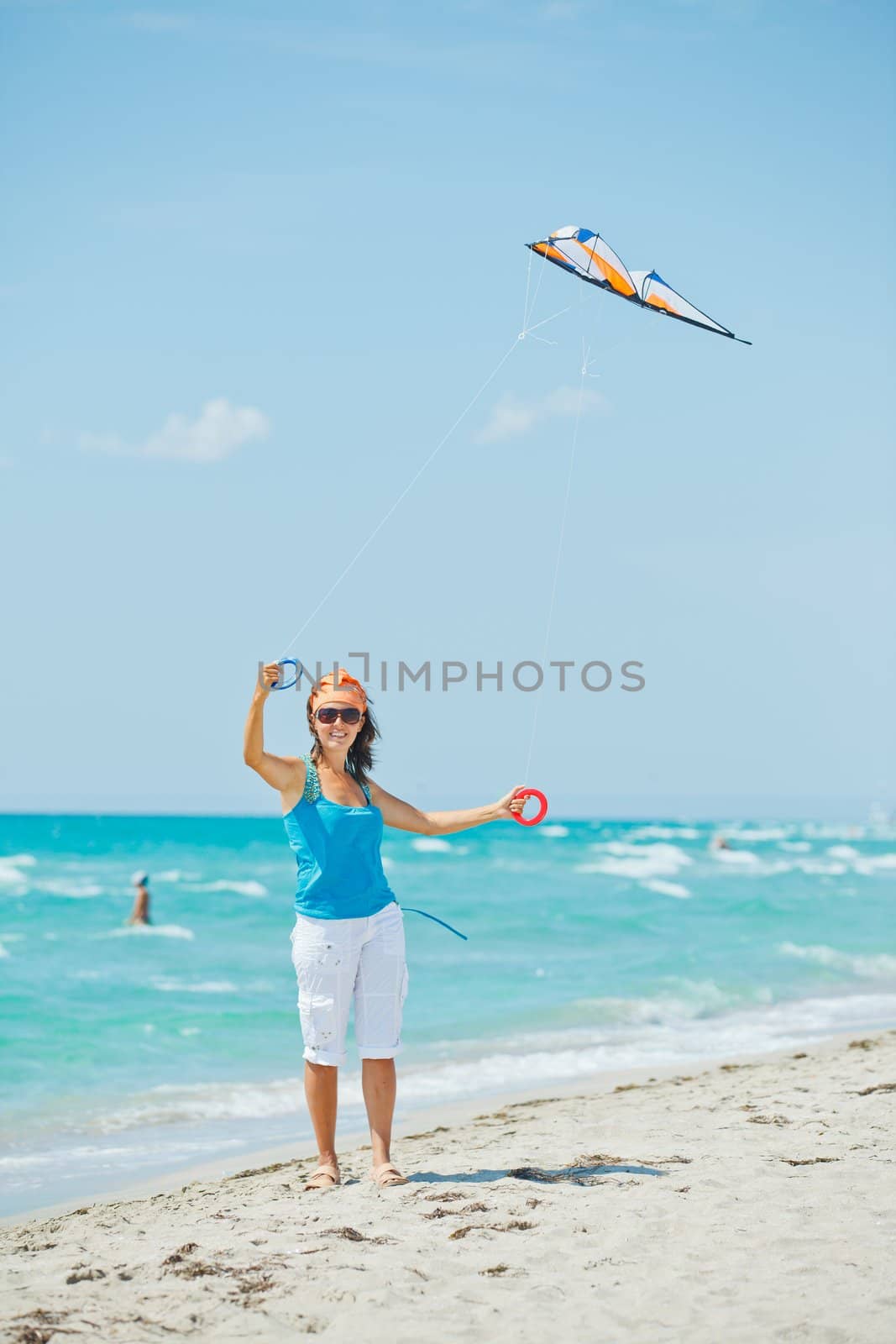 Young cute woman playing with a colorful kite on the tropical beach. Vertikal veiw