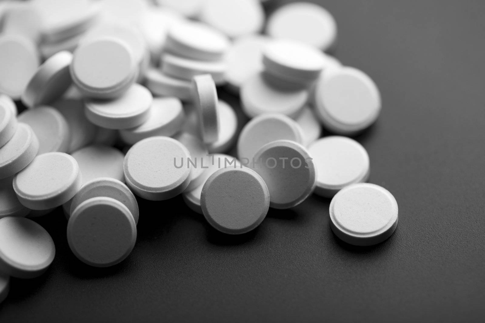 white pills over black background