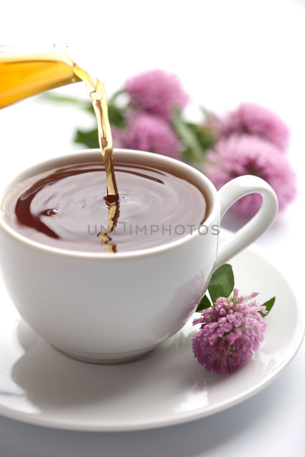 tea pouring into white cup isolated