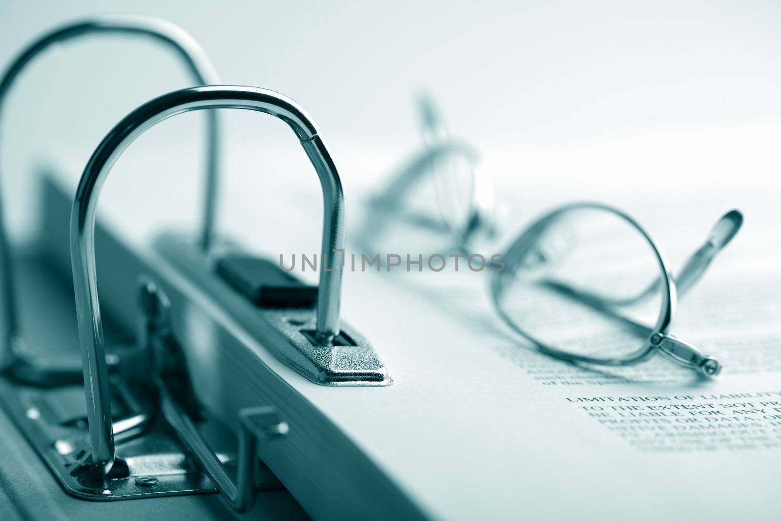 open binder and glasses over document toned blue