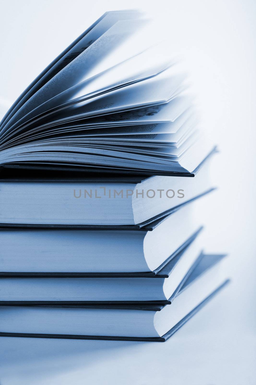 pile of books with one book open