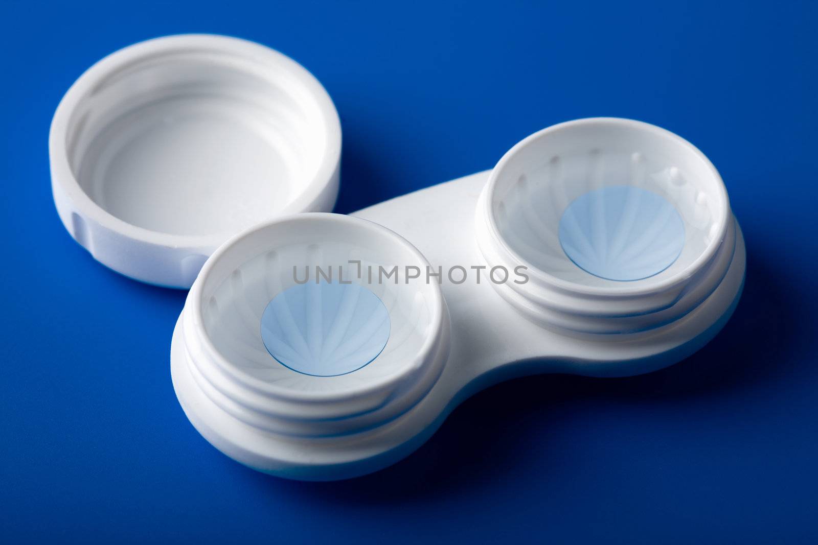 blue contact lens in white container
