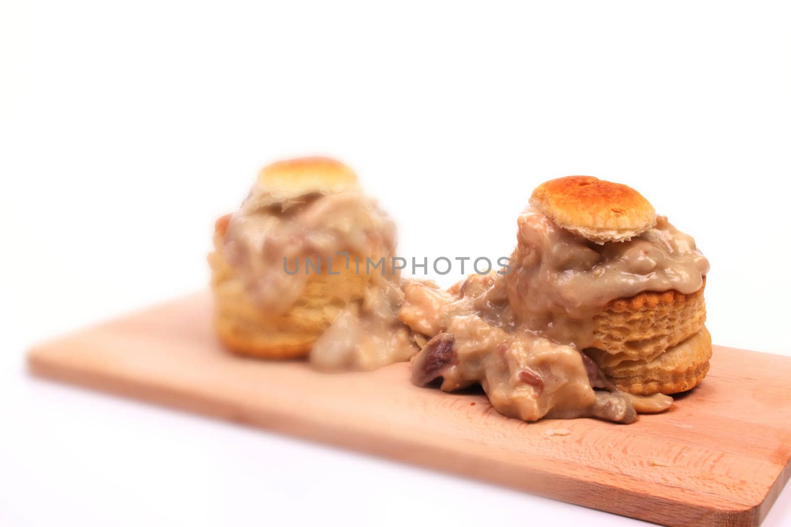 Vol-au-vent on a wooden plate against a white background