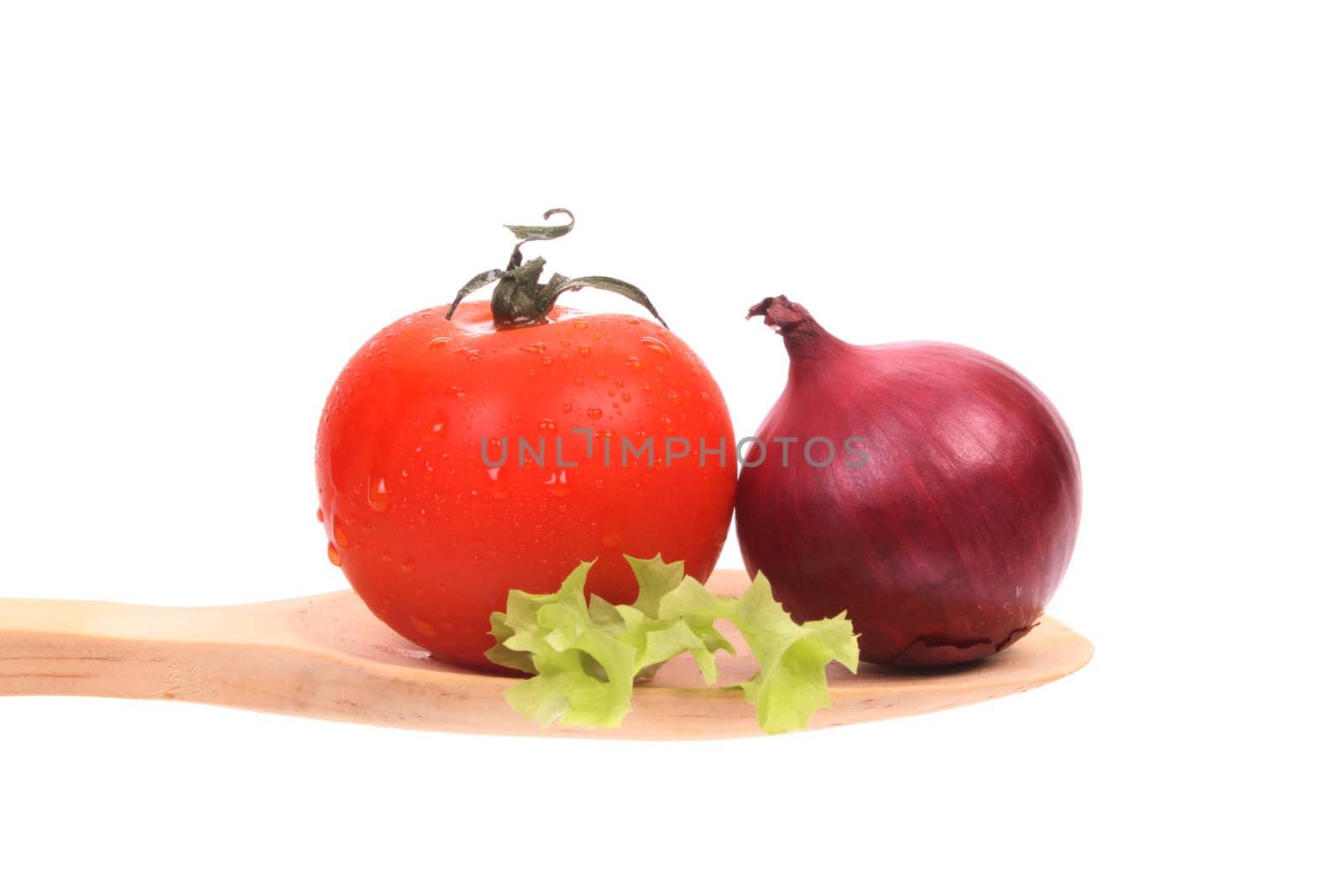Ingredients to make a healthy salad, presented on a wooden spoon