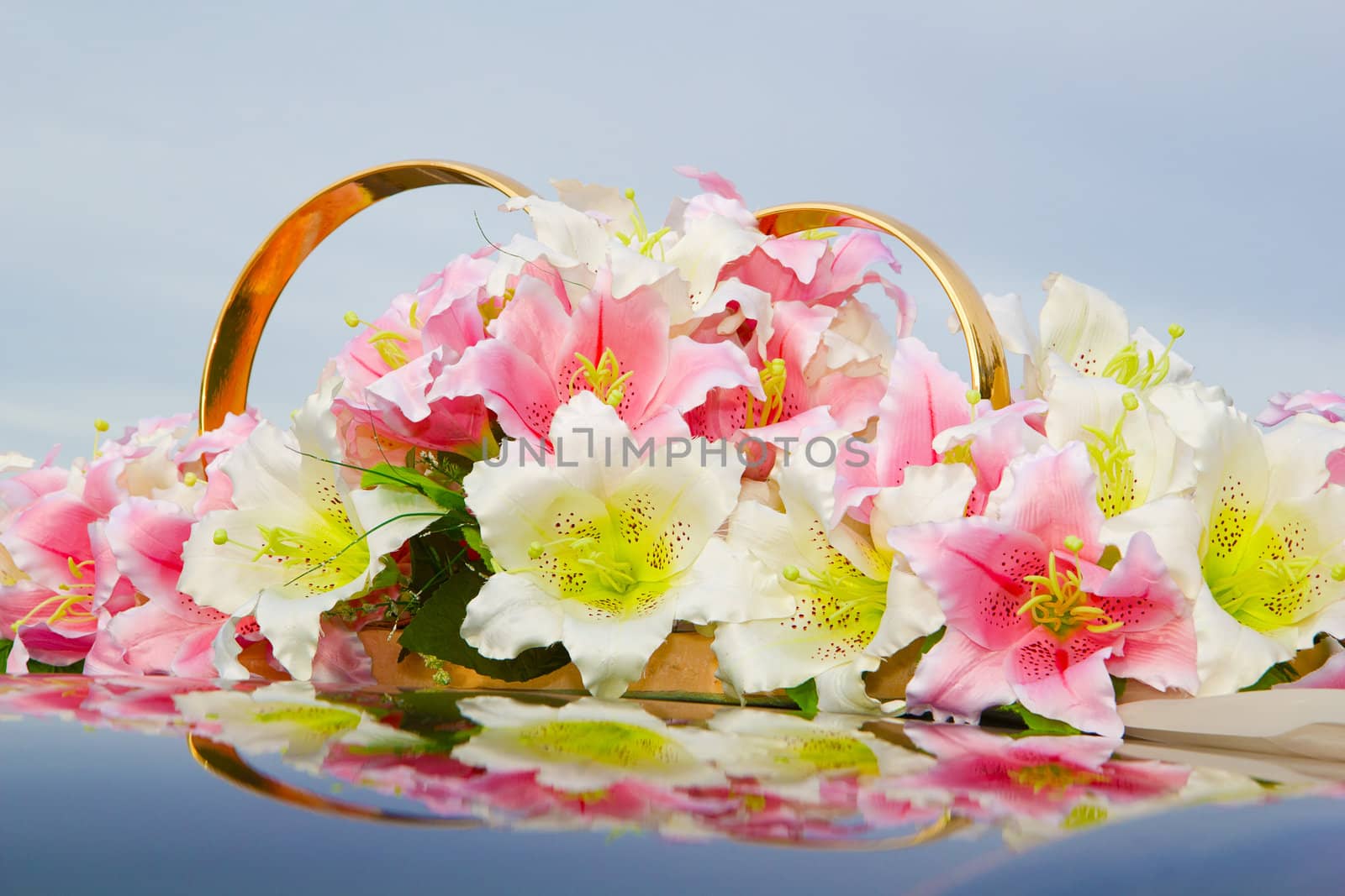 Wedding decoration of flowers and rings on the roof of the car