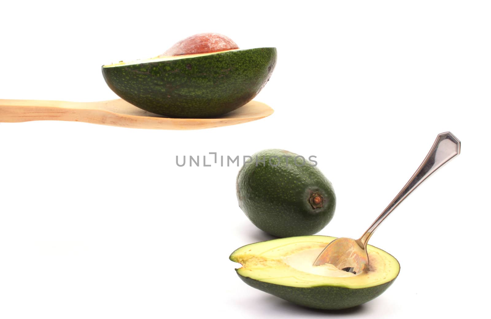 Avocado presented on a wooden spoon against a white background