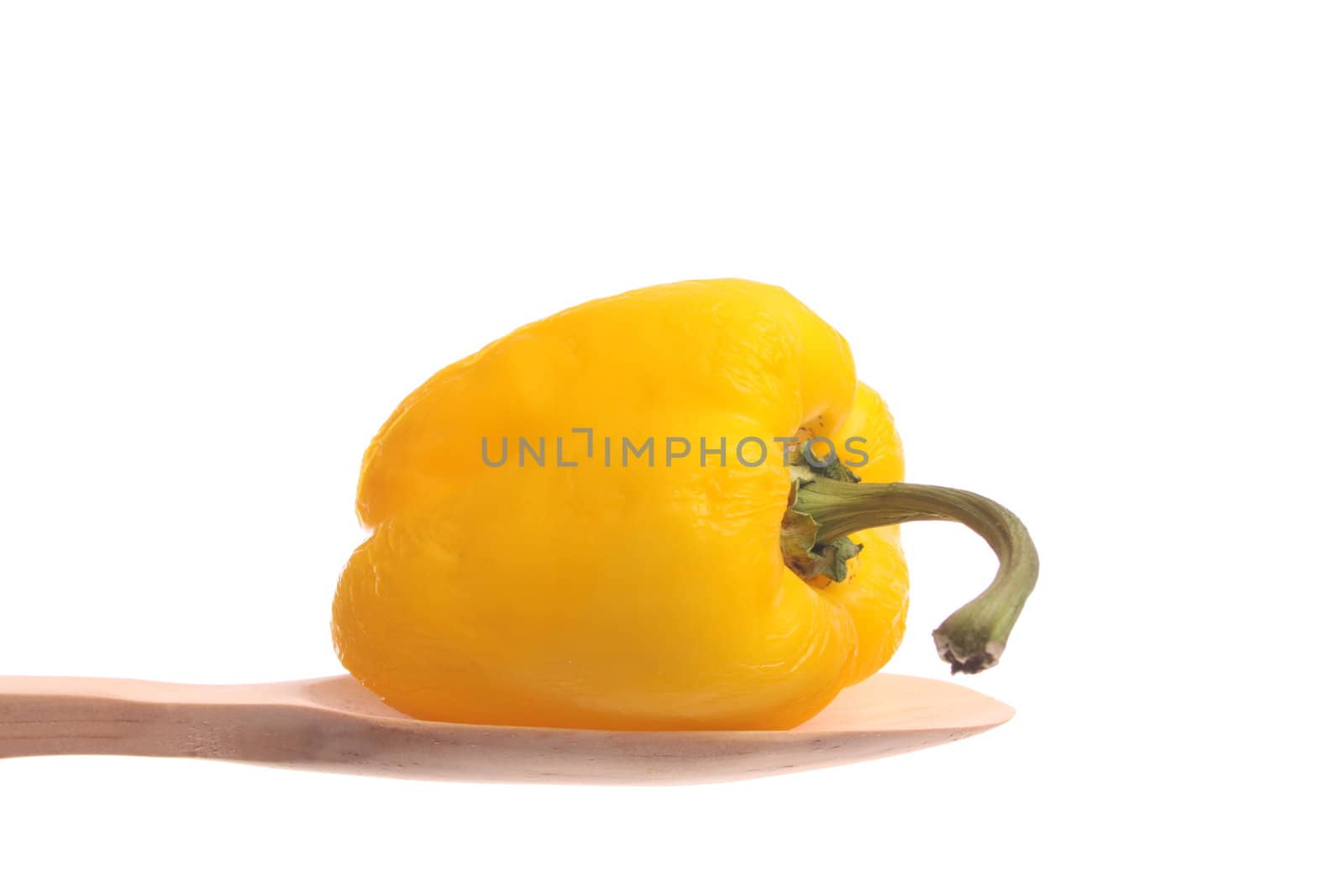 Old bell pepper simply offered on a wooden spoon isolated on a white background 