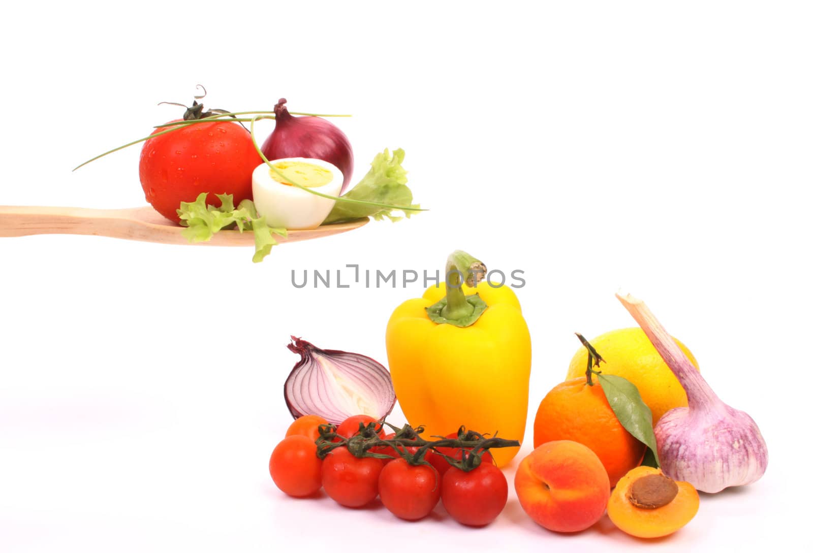 Ingredients to make a healthy salad, presented on a wooden spoon