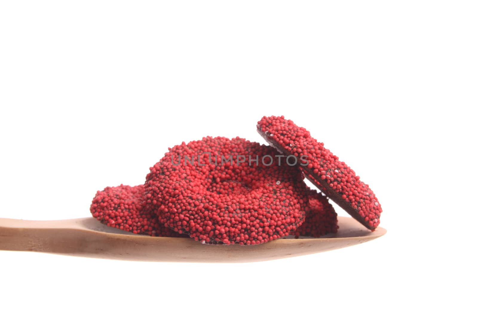 Chocolate cookies simply offered on a wooden spoon isolated on a white background 