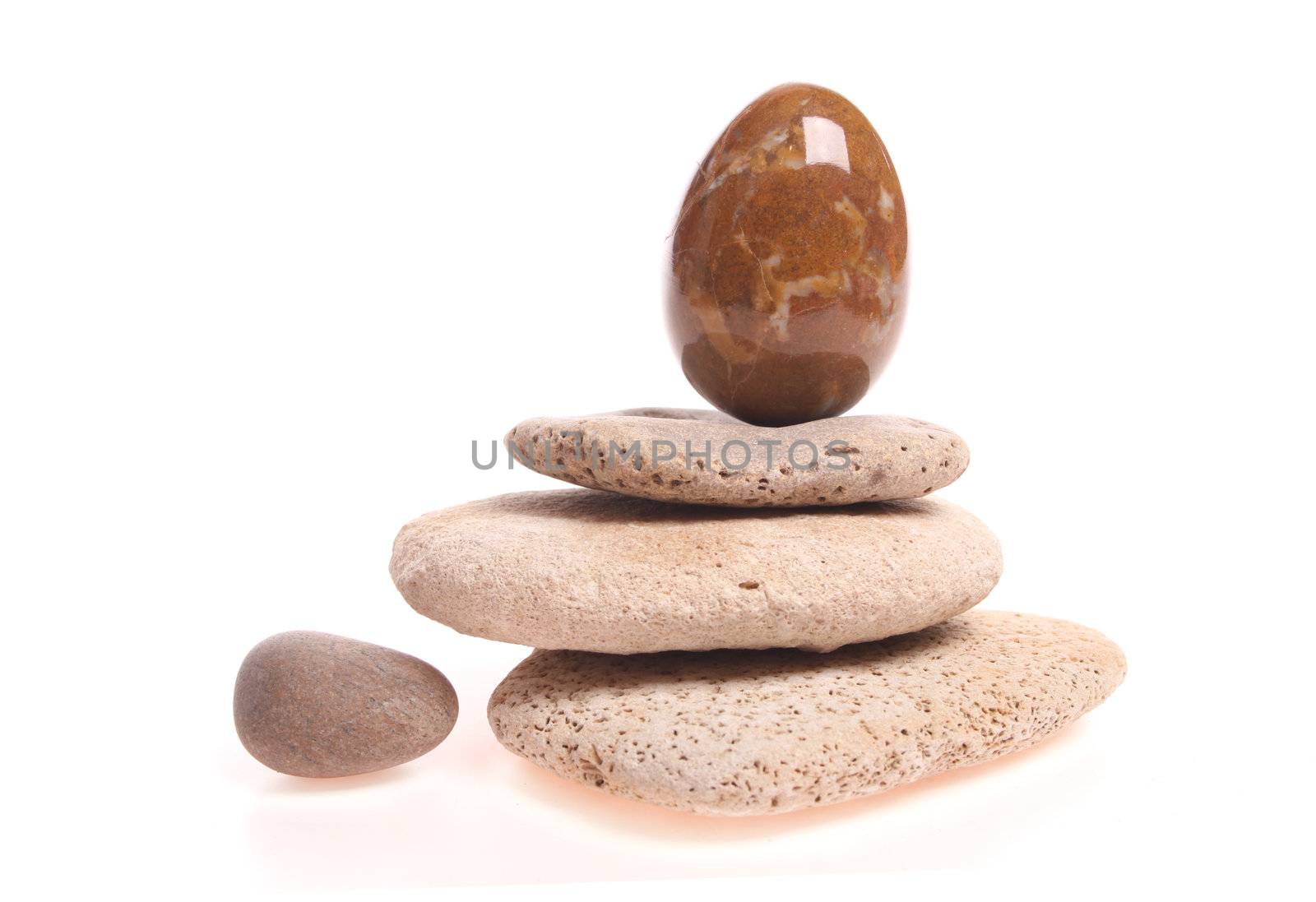Easter egg on a pile of stones isolated against a white background with copy space